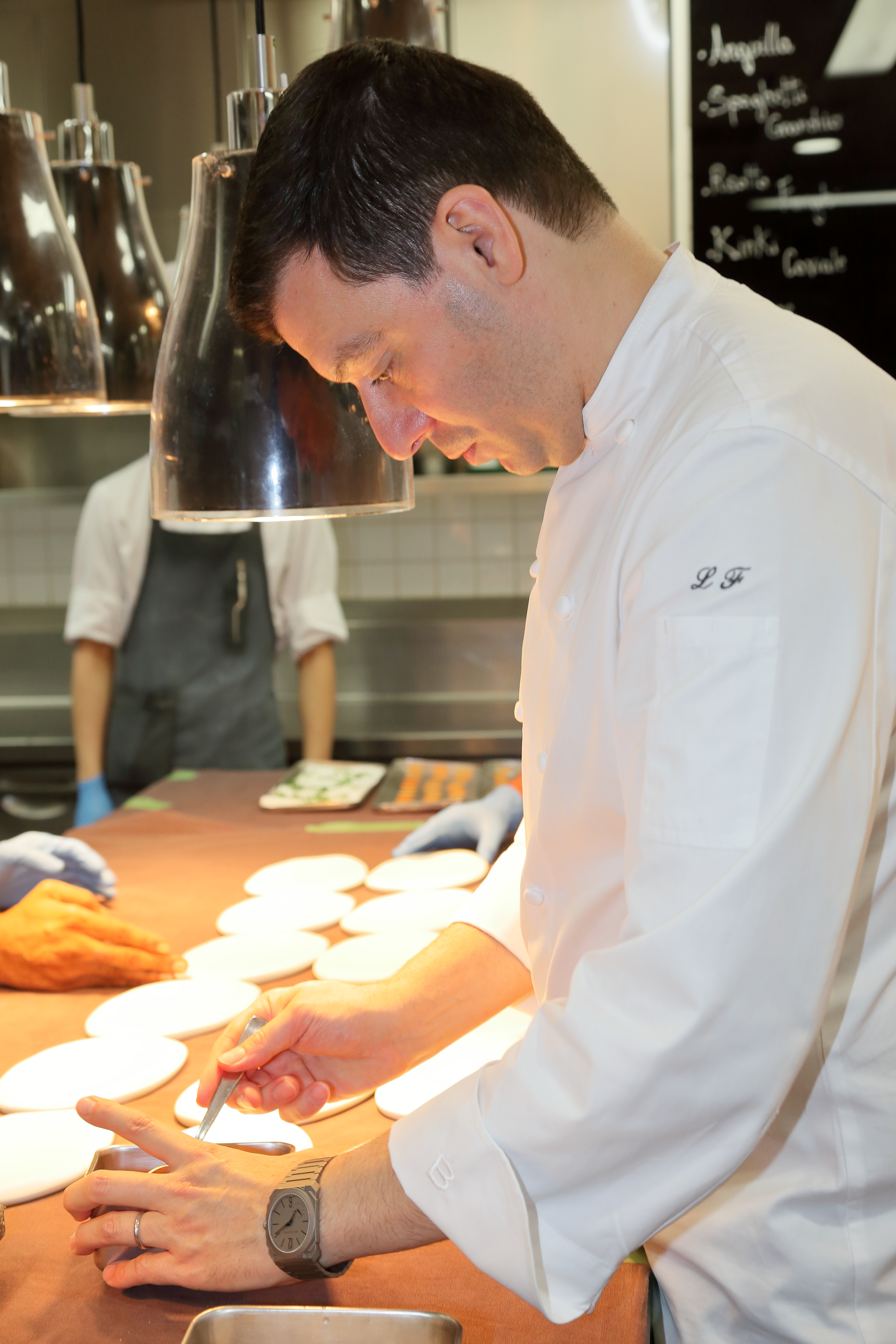 A chef in black gloves prepares stir fry vegetables. Concept of cooking healthy organic food